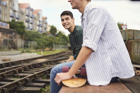 2名青年男子坐在火车轨道旁英国布里斯托尔图片