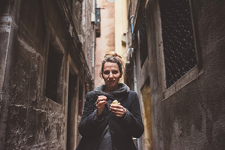 黑暗小巷里年轻女人吃冰淇淋图片