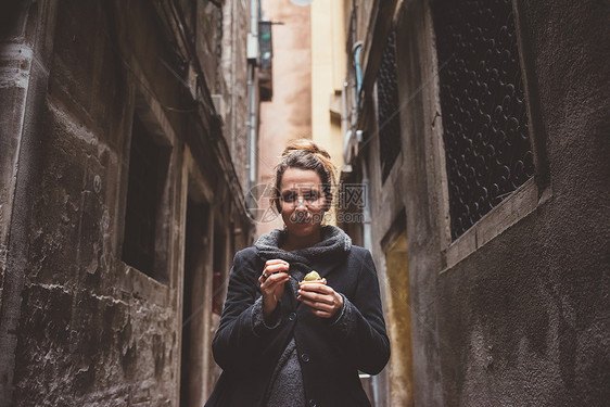 黑暗小巷里年轻女人吃冰淇淋图片