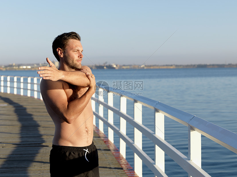 海边伸展运动的男子图片