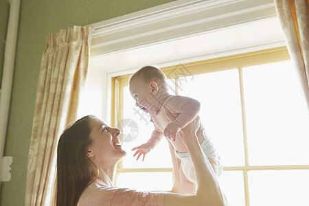 妇女把婴抱起图片