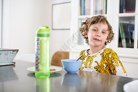 男孩在厨房桌上吃早餐图片