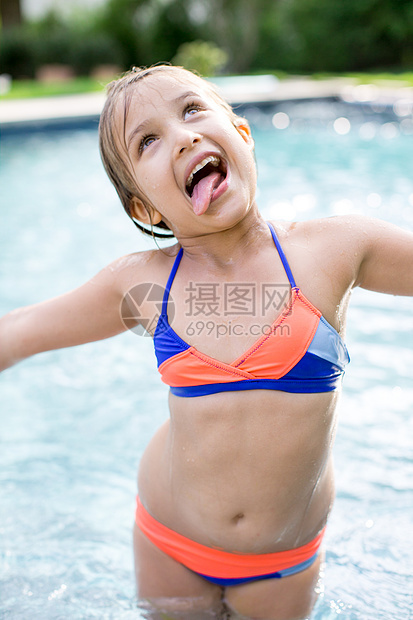 站在户外游泳池的女孩伸出舌头图片