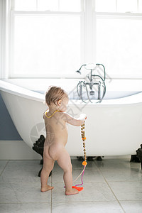 在浴室里玩珠子的男幼儿背景图片