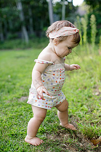 花园草坪上的赤脚行走的小女孩图片