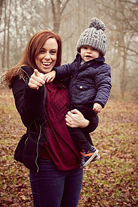 在森林中抱着小男孩的母亲图片