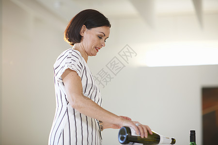 在美术画廊开幕时女美人倒白葡萄酒图片