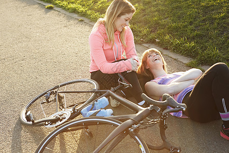赛车周期在公园休息的女骑自行车者图片