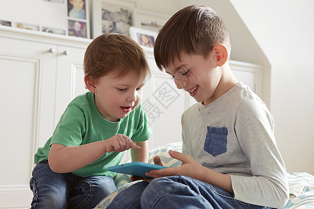 男孩和兄弟看数字平板电脑图片