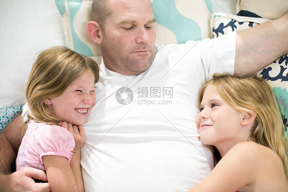 床上两个女儿之间成熟男子的阴影视线图片