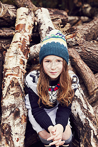 年轻女孩的肖像坐在木桩上图片