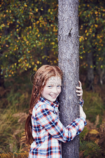 年轻女孩的肖像拥抱树微笑图片
