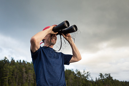 美国缅因州海岸的老年人通过望远镜寻找图片