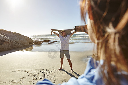南非开普敦一个成熟的女人在海滩上为男人拍照图片