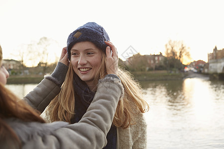 年轻女人在朋友户外微笑的朋友容上戴织帽的年轻女人图片