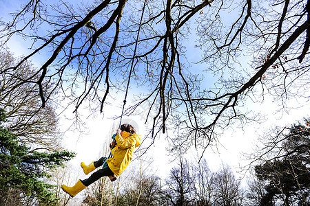 从公园树上摇动的黄色脉男孩图片
