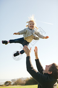 女幼儿由父亲在天空中向蓝投掷空图片