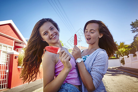 两个女朋友的肖像户外握着冰棒图片