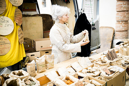 在当地市场销售干食品的老人图片
