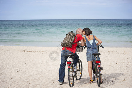 在西班牙马洛卡的海滩上骑自行车的夫妇图片