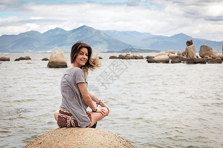 圣卡塔琳娜坐在岩石上回头看着镜头微笑的少女背景