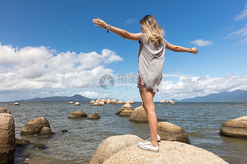 少女在海边岩石上图片