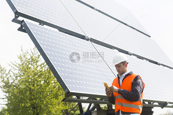 年轻男工程师在操作太阳能电池板图片