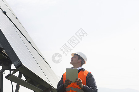 年轻男工程师在操作太阳能电池板图片