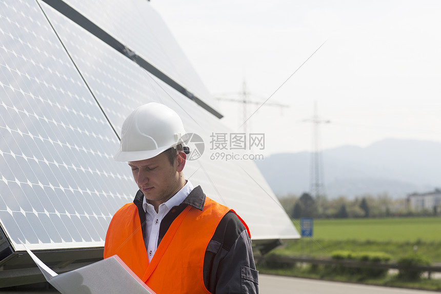 年轻男工程师在操作太阳能电池板图片