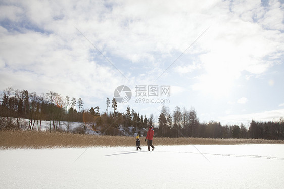 父亲和孩子在雪地里行走图片