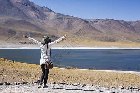 智利圣佩德罗德阿塔卡马米桑蒂湖边的妇女举起双臂图片