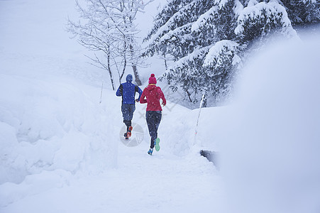 瑞士格斯塔德大雪中的男女跑步者图片