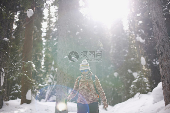 加拿大路易湖冰雪覆盖的森林中拿着登山杖的女人图片
