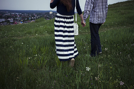年轻夫妇走在草地手牵手图片