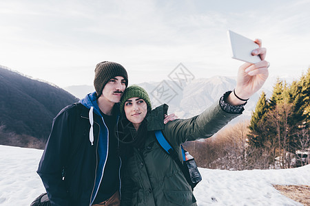意大利圣普里莫山一对徒步旅行的夫妇在雪山上自拍图片