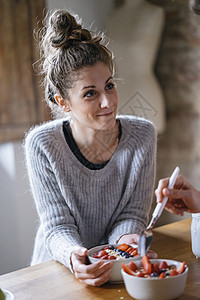 在厨房柜台吃水果的年轻夫妇图片