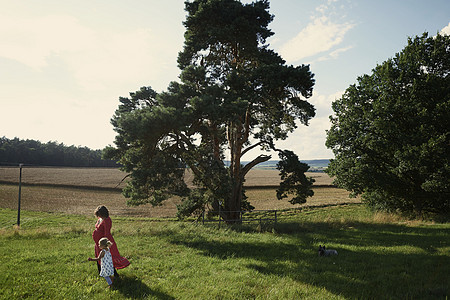 孕妇和女幼儿在田地中漫步图片