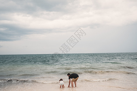 父亲和女儿在墨西哥坎昆海滩玩耍图片