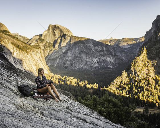 女孩安静地坐在美国加利福尼亚州Yosemite公园山谷中图片