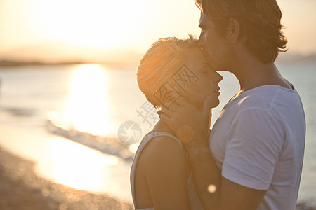 在海滩上亲吻女人额头的男人图片