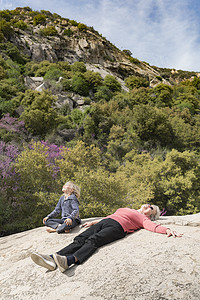 孙子和祖母在岩石上休息图片