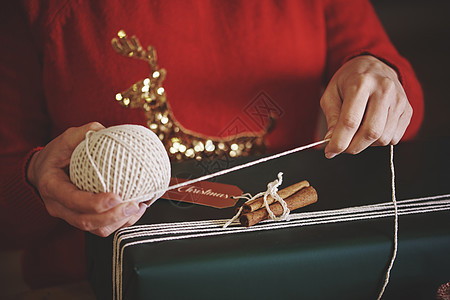 妇女用麻绳打包圣诞节礼物图片