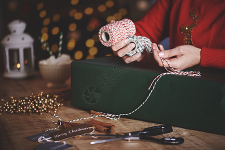 妇女用麻绳打包圣诞节礼物图片