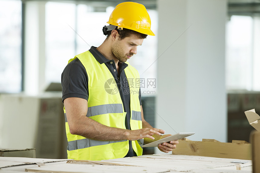 男子站在新建空间看平板电脑图片