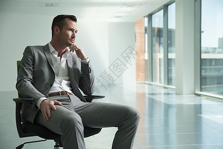 坐在办公间椅子上思考的商人图片