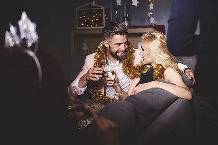 派对上的男人和女坐在沙发上喝酒敬图片