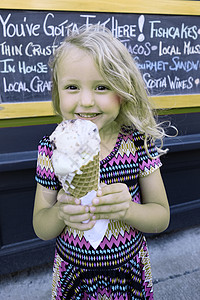 穿着大冰淇淋甜筒的金发女孩在微笑图片