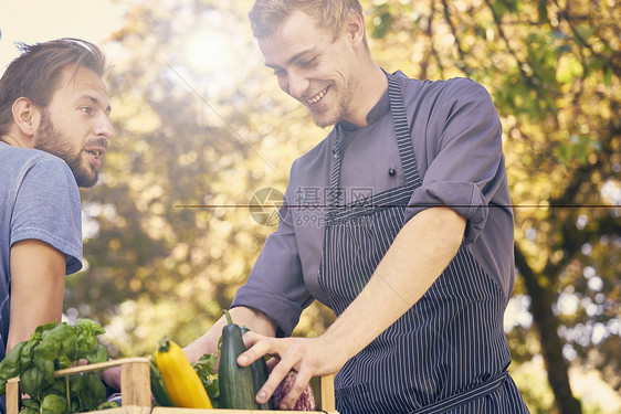 接受一箱蔬菜送货的厨师图片