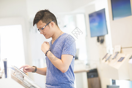 在技术商店使用触摸屏的男子图片