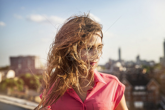 在英国伦敦的屋顶派对上长风毛发的年轻女子图片